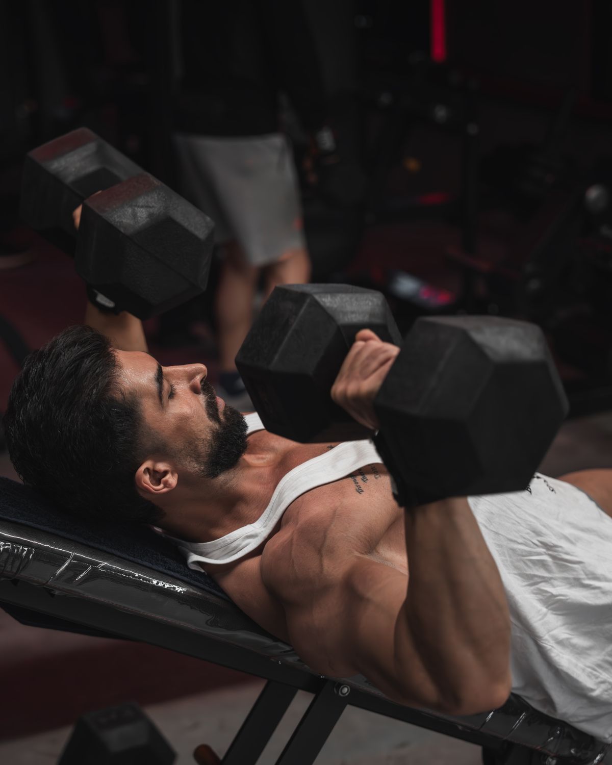 Man pressing dumbbells on an incline bench