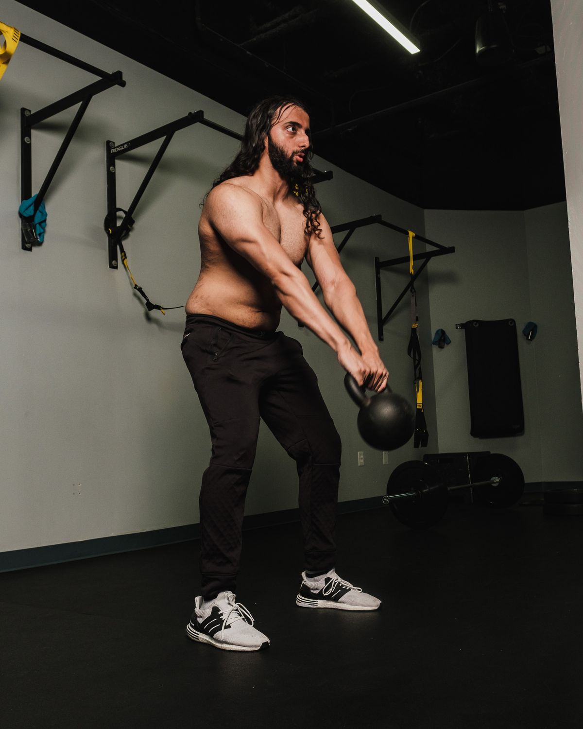 Man doing a kettlebell swing in a gym